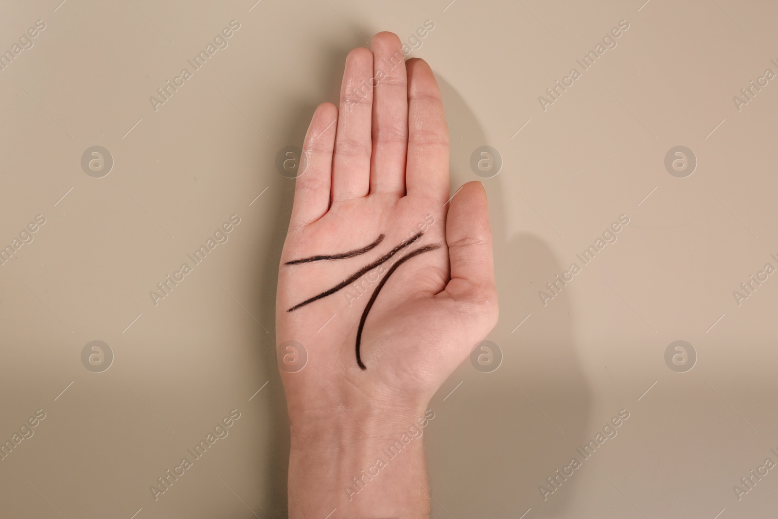 Photo of Woman showing palm with drawn lines on color background, top view. Chiromancy and foretelling