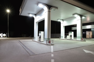 Photo of Modern gas station with convenience store beside the road at night