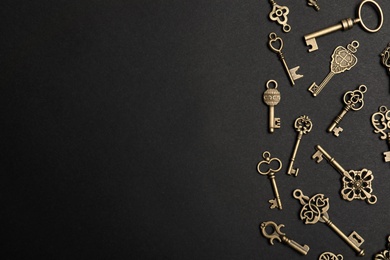 Photo of Flat lay composition with bronze vintage ornate keys on dark background, space for text