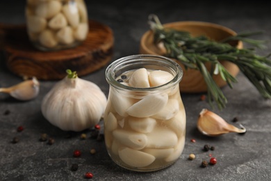 Photo of Composition with jar of pickled garlic on grey table