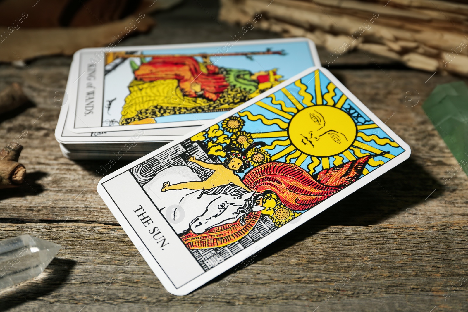 Photo of Sun and other tarot cards on wooden table, closeup