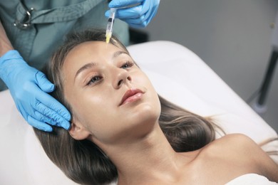 Photo of Beautiful woman getting facial injection in salon