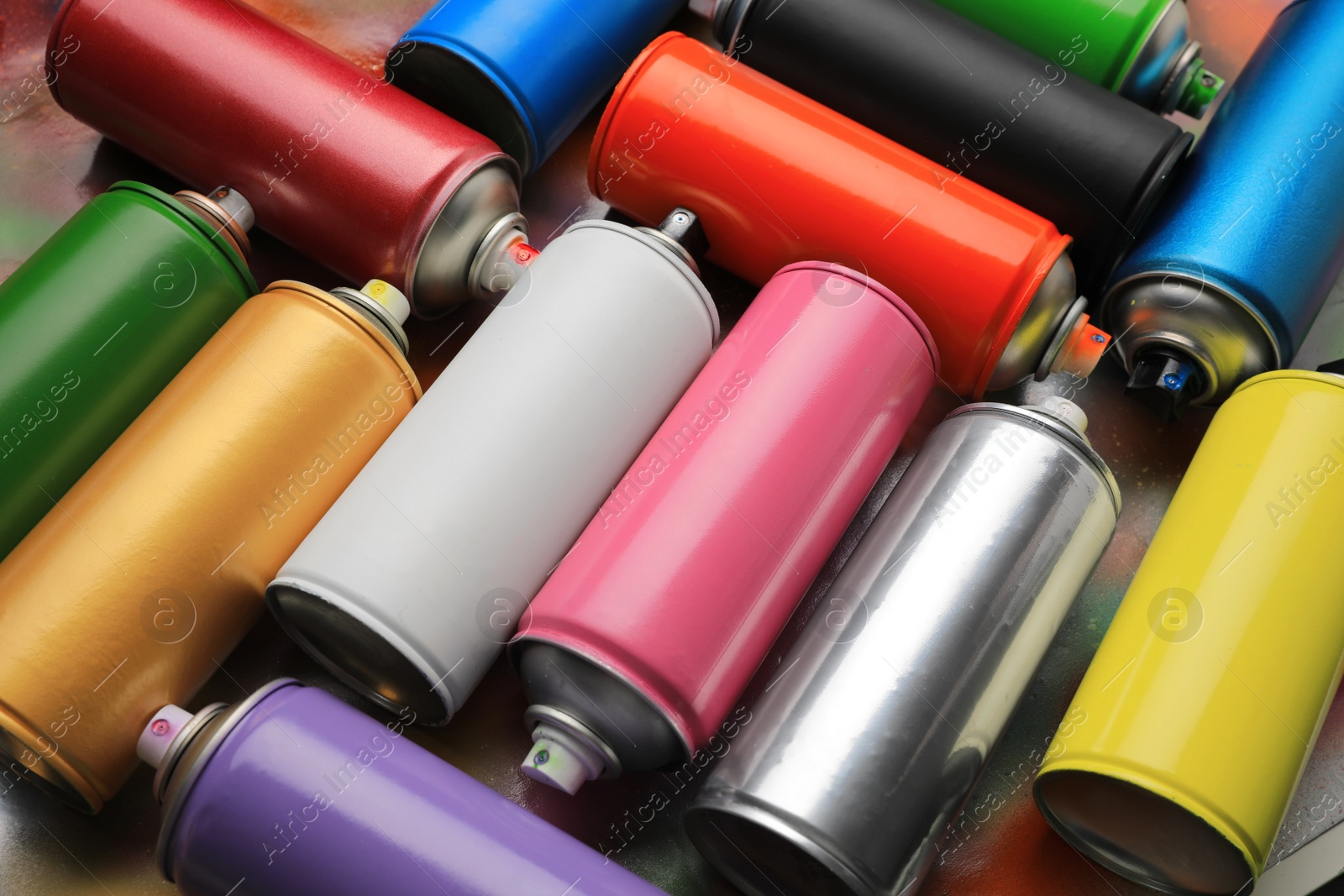 Photo of Cans of different graffiti spray paints on color background