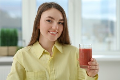 Photo of Beautiful young woman with delicious smoothie at home