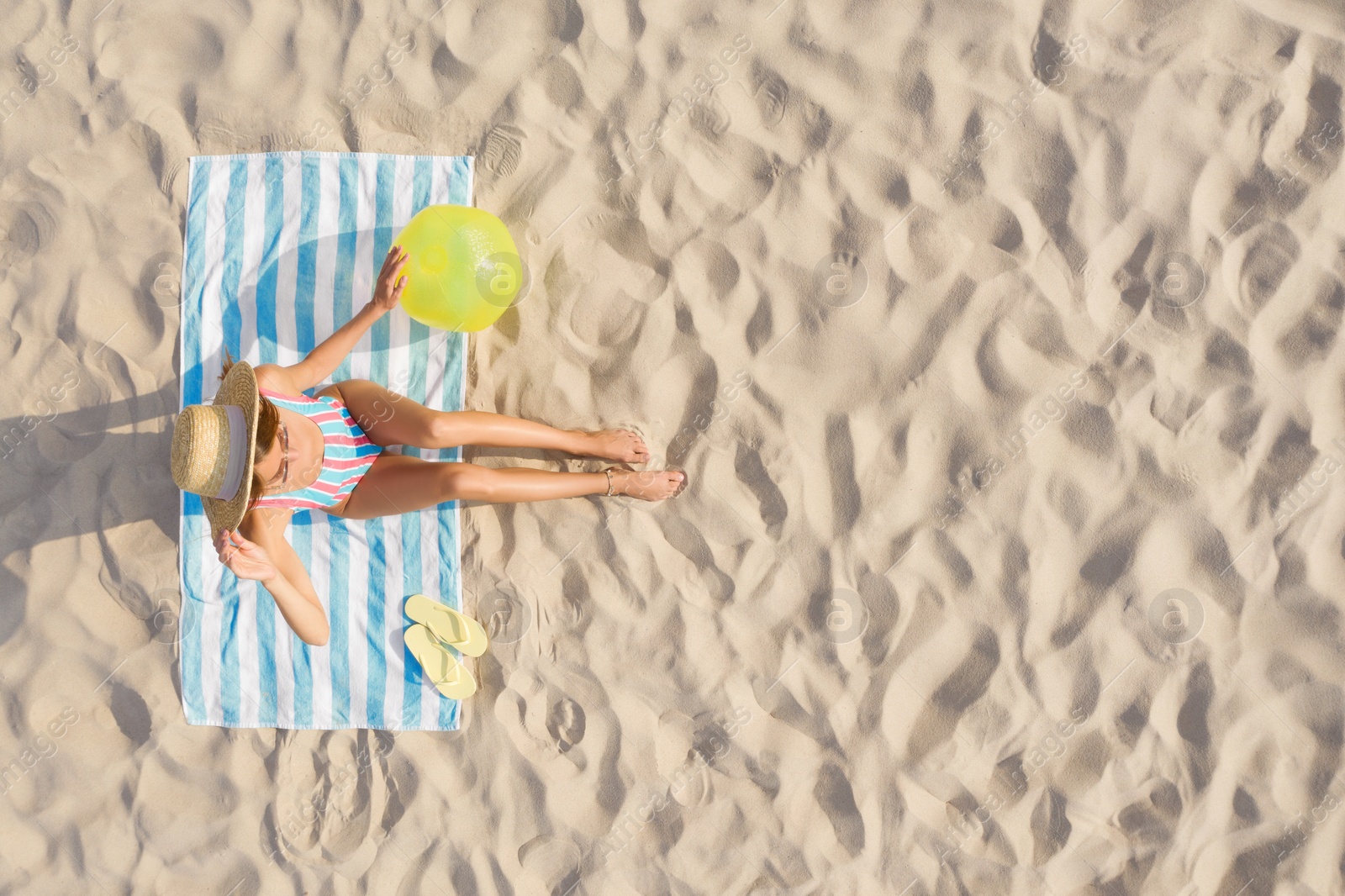Image of Woman sunbathing on beach towel at sandy coast, aerial view. Space for text