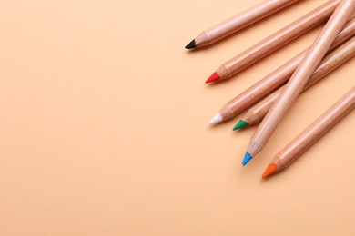 Photo of Colorful pastel pencils on beige background, space for text. Drawing supplies