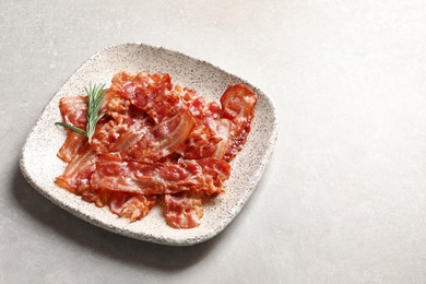 Photo of Plate with fried bacon on grey background