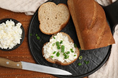 Photo of Bread with cottage cheese and green onion on wooden table, flat lay