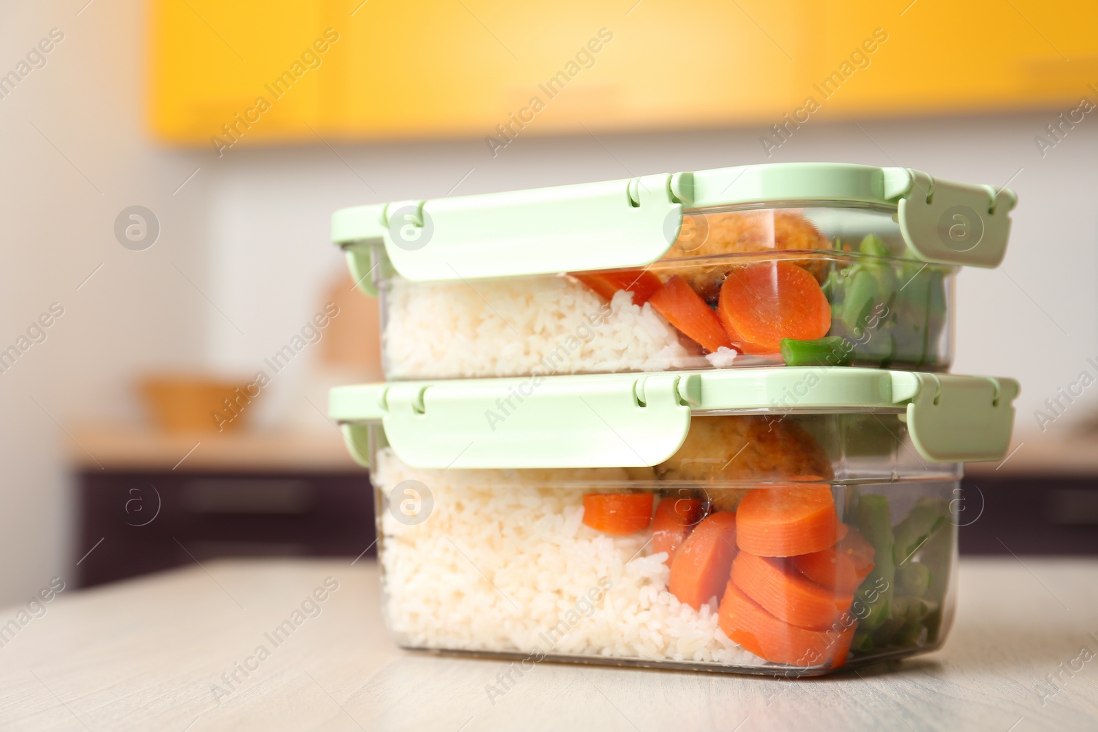 Photo of Boxes with prepared meals on table against blurred background