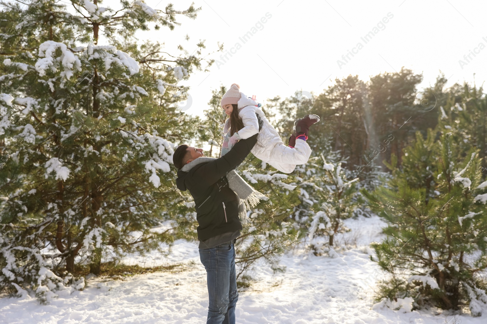 Photo of Happy father and daughter playing outdoors on winter day. Christmas vacation