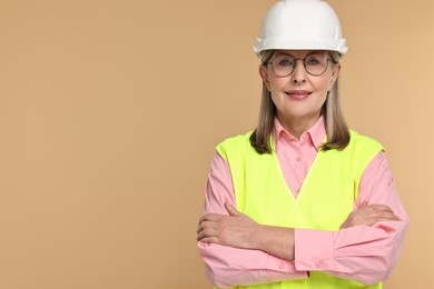 Photo of Architect in hard hat on beige background, space for text