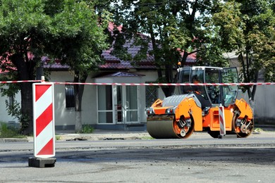 Photo of Modern roller working on city street. Road repair