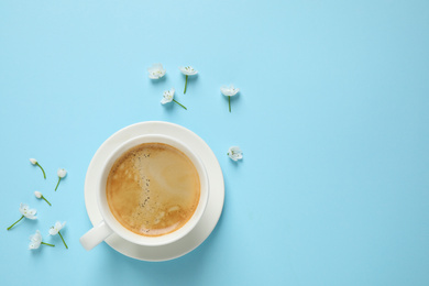 Photo of White flowers and coffee on light blue background, flat lay with space for text. Good morning