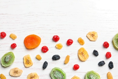 Flat lay composition with different dried fruits on wooden background, space for text. Healthy lifestyle