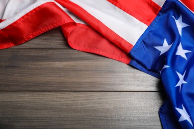 Photo of American flag on wooden table, top view. Space for text