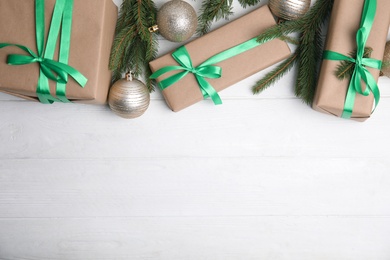 Flat lay composition with Christmas gift boxes on white wooden table. Space for text