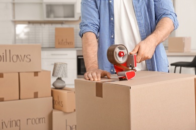 Photo of Man packing moving box indoors, closeup. Space for text