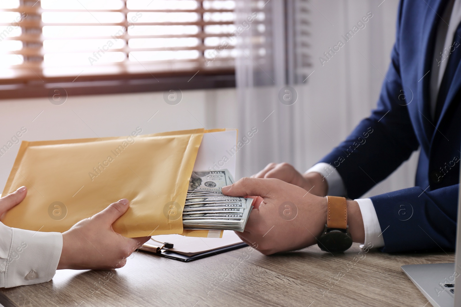 Photo of Woman giving bribe to man at table in office, closeup