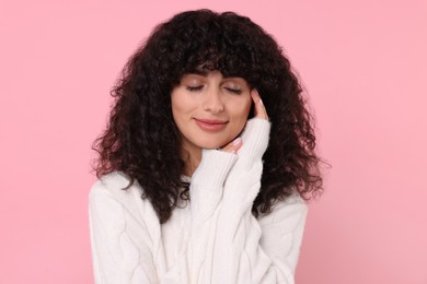 Photo of Young woman in stylish white sweater on pink background