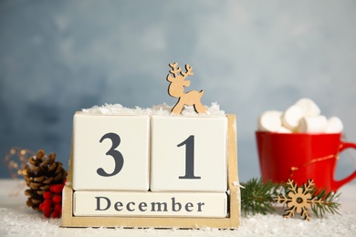 Photo of Wooden block calendar and festive decor on table