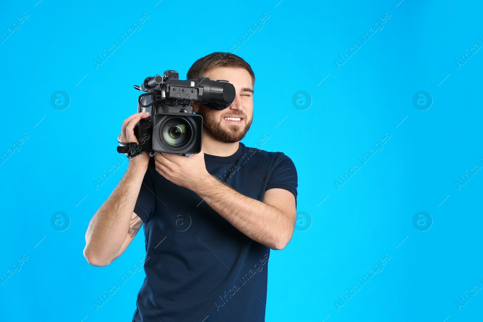 Photo of Operator with professional video camera on blue background