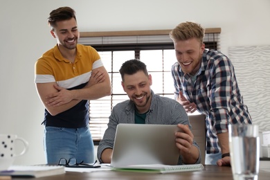 Image of Happy friends working together in modern office