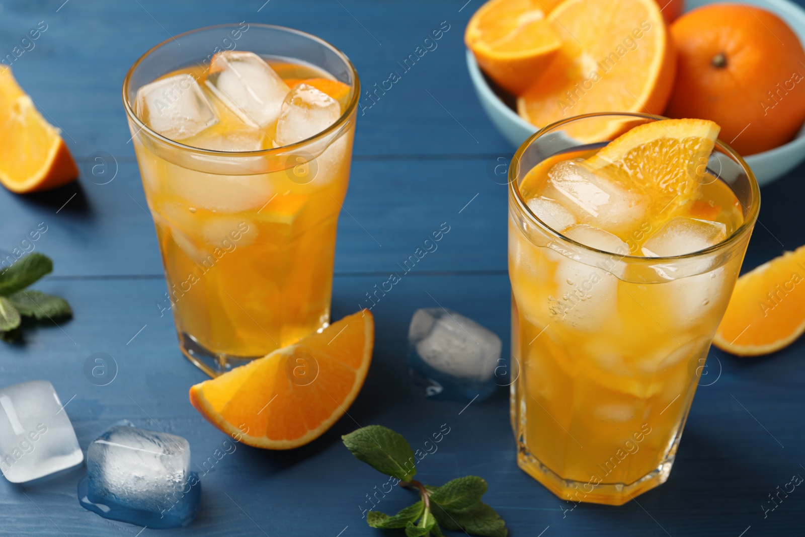 Photo of Delicious orange soda water on blue wooden table