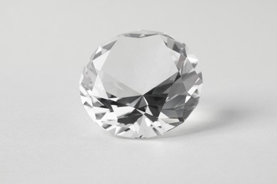 Photo of Beautiful dazzling diamond on light background. Precious gemstone