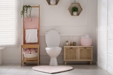 Stylish bathroom interior with toilet bowl and other essentials