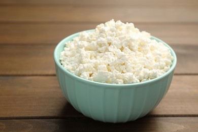 Photo of Delicious fresh cottage cheese on wooden table, closeup