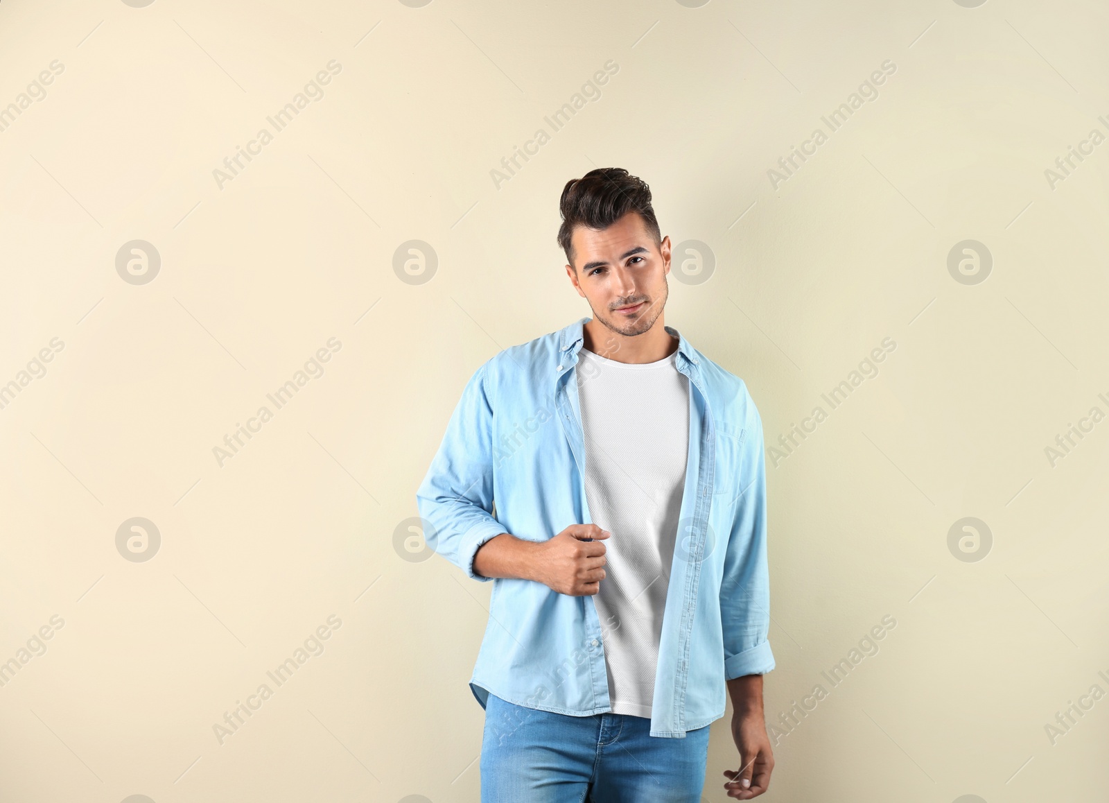 Photo of Young man in stylish jeans on light background