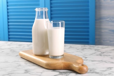 Glassware with tasty milk on white marble table