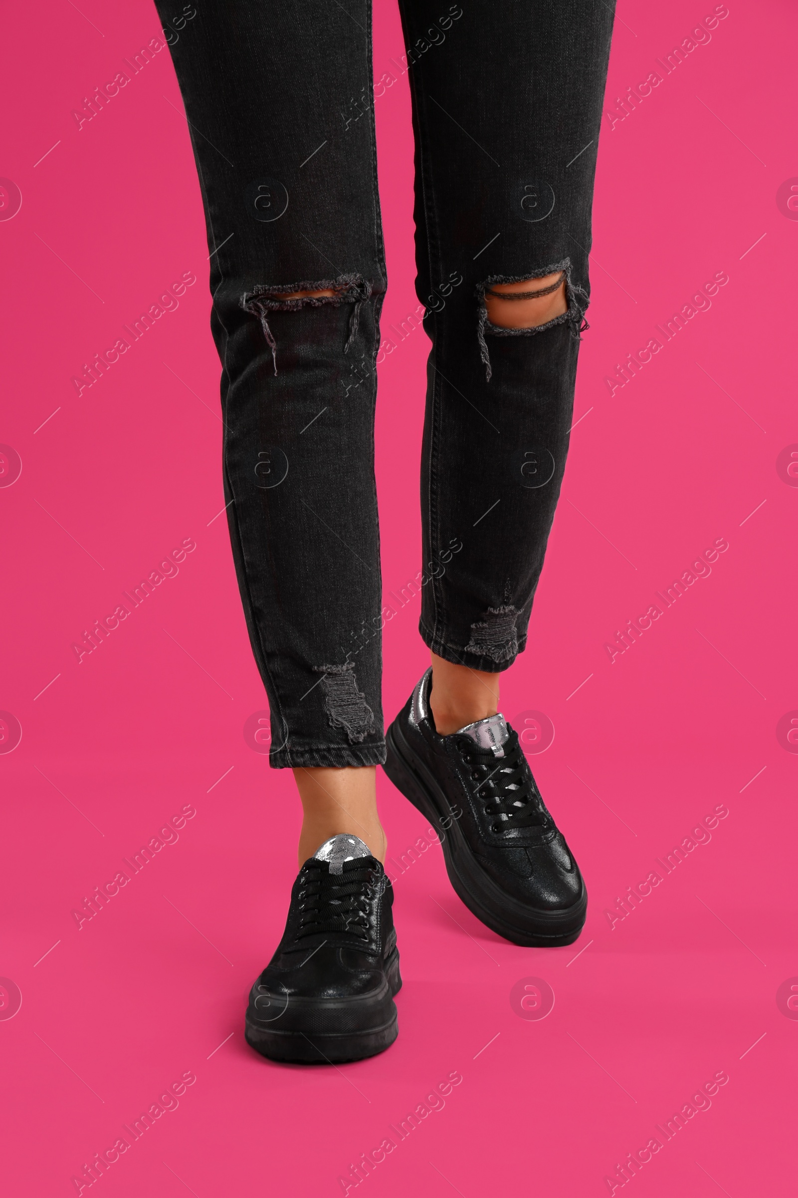 Photo of Woman wearing shoes on pink background, closeup