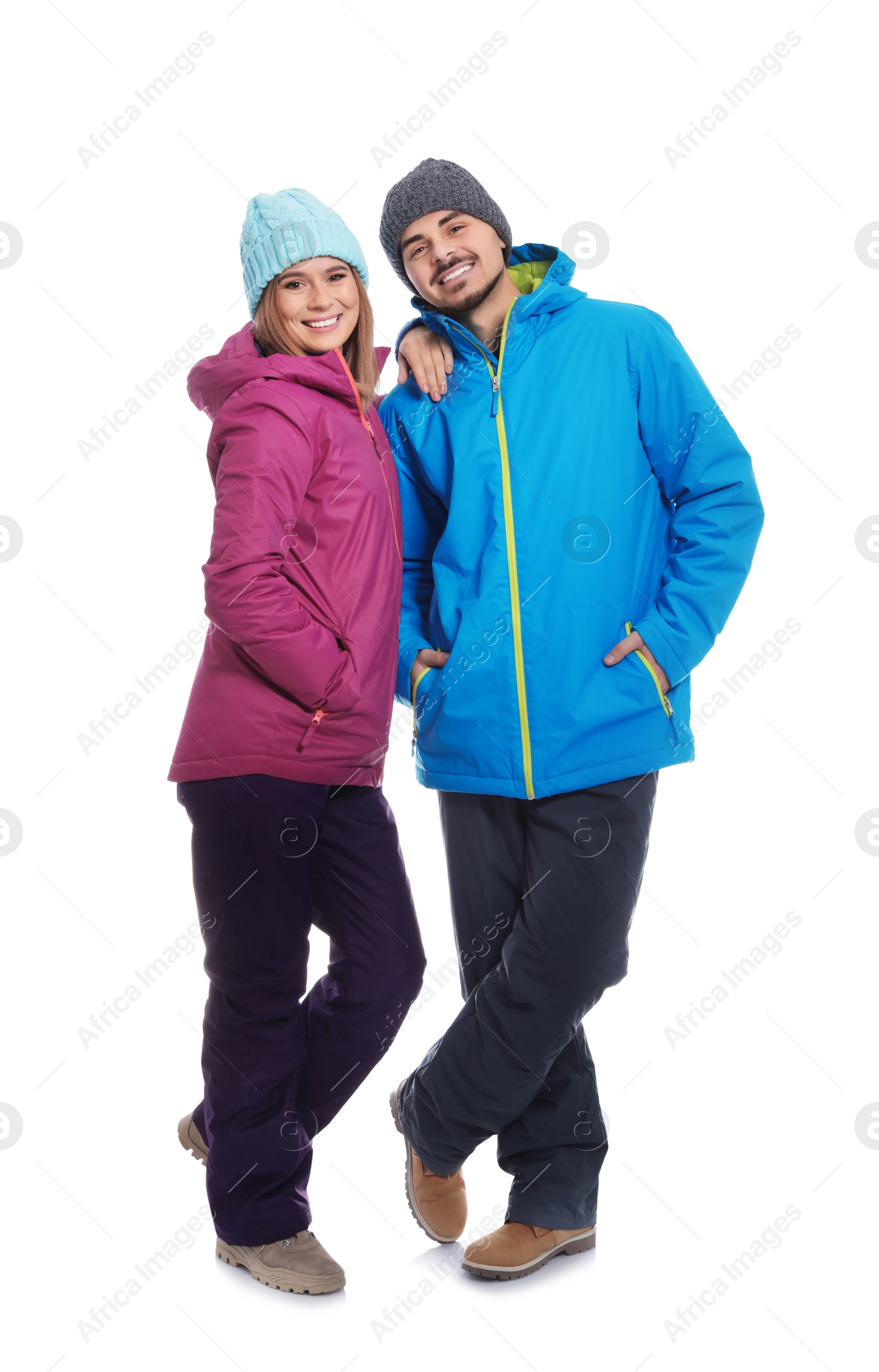 Photo of Young couple wearing warm clothes on white background. Ready for winter vacation