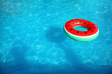 Inflatable ring floating in swimming pool on sunny day