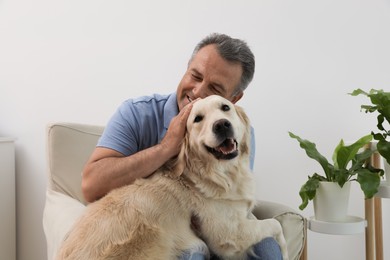 Photo of Happy senior man with his Golden Retriever dog at home