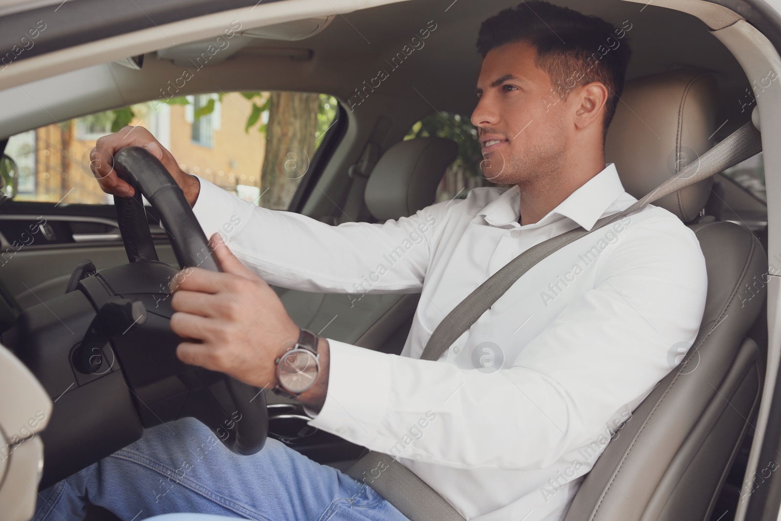 Photo of Male driver with fastened safety belt in car