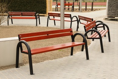 Photo of Many new wooden benches in city park