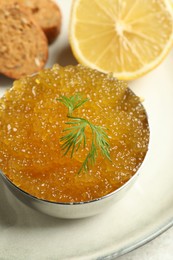 Photo of Fresh pike caviar in bowl, lemon and bread on table, closeup