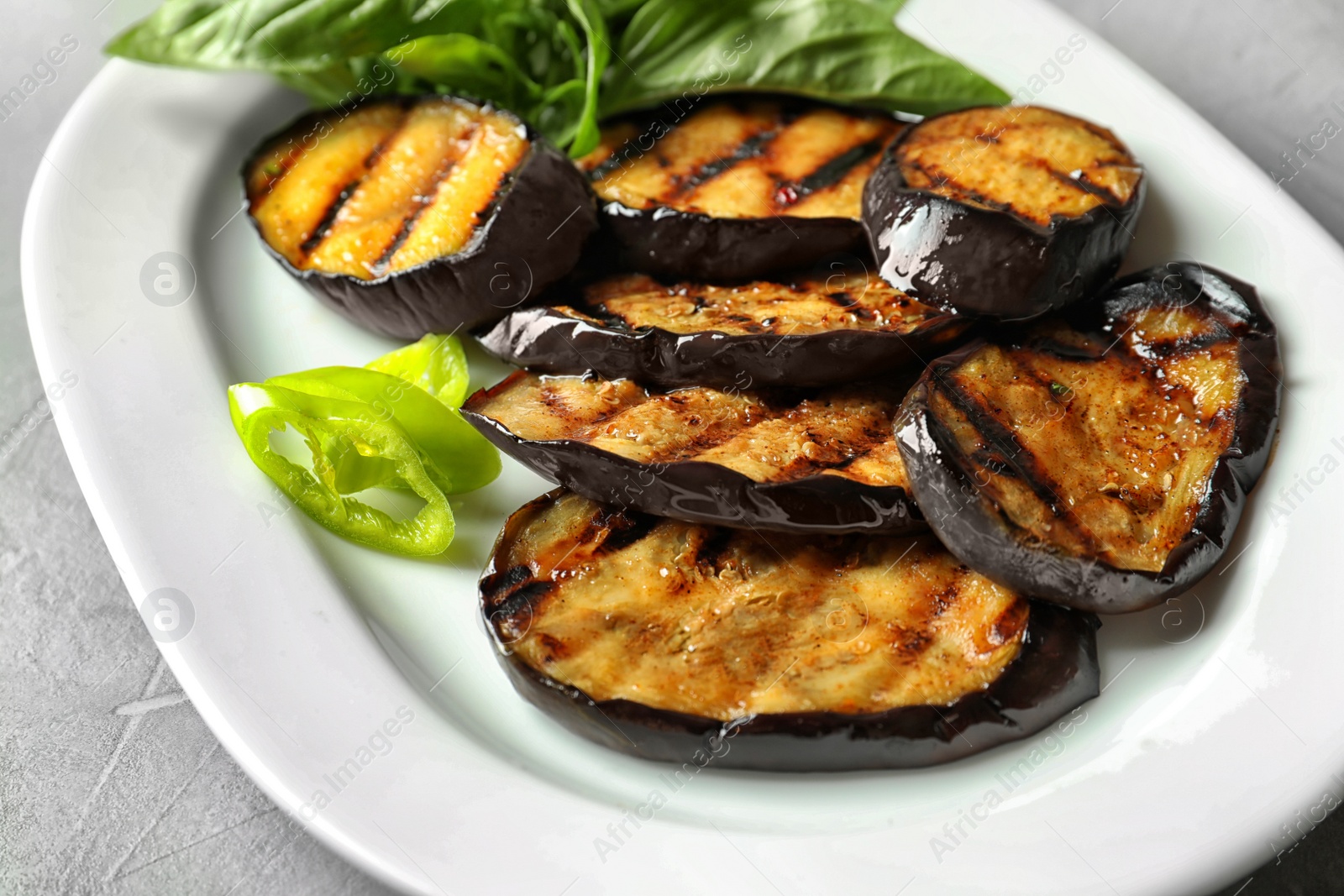 Photo of Plate with fried eggplant slices on table, closeup