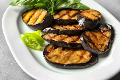 Plate with fried eggplant slices on table, closeup