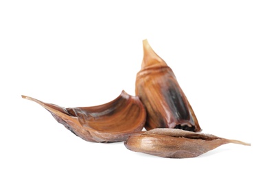 Photo of Unpeeled cloves of aged black garlic on white background