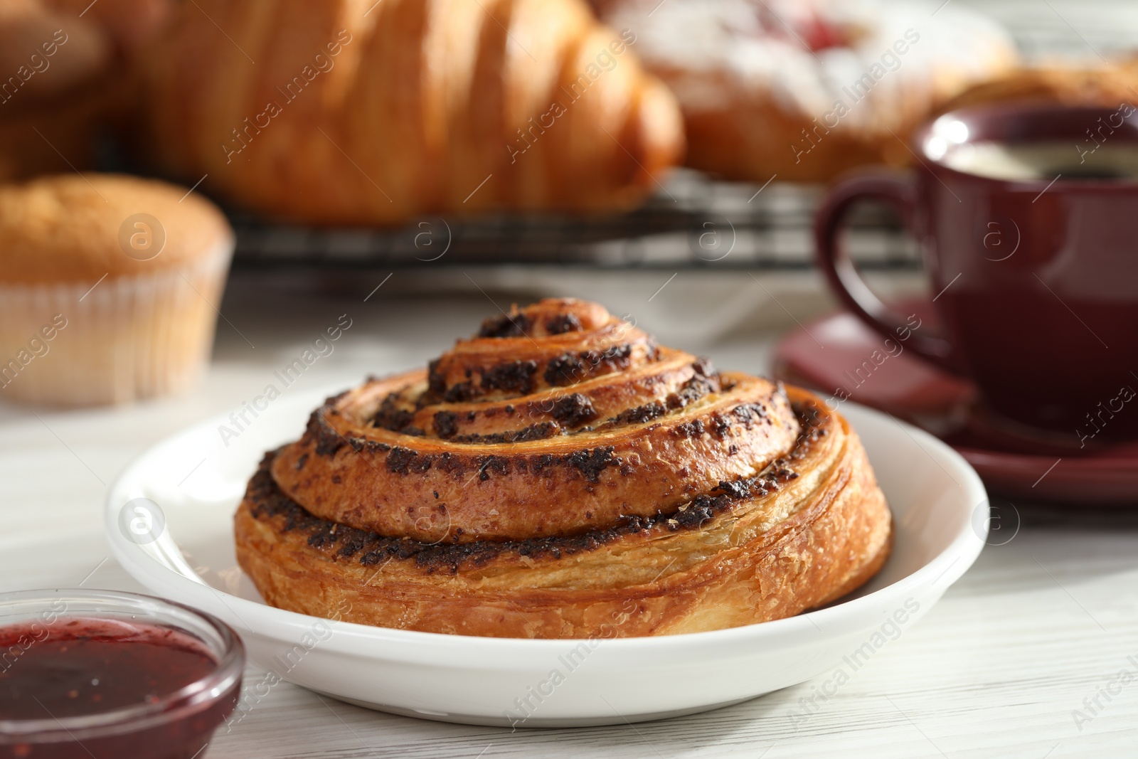 Photo of Tasty freshly baked spiral pastry on white wooden table, closeup