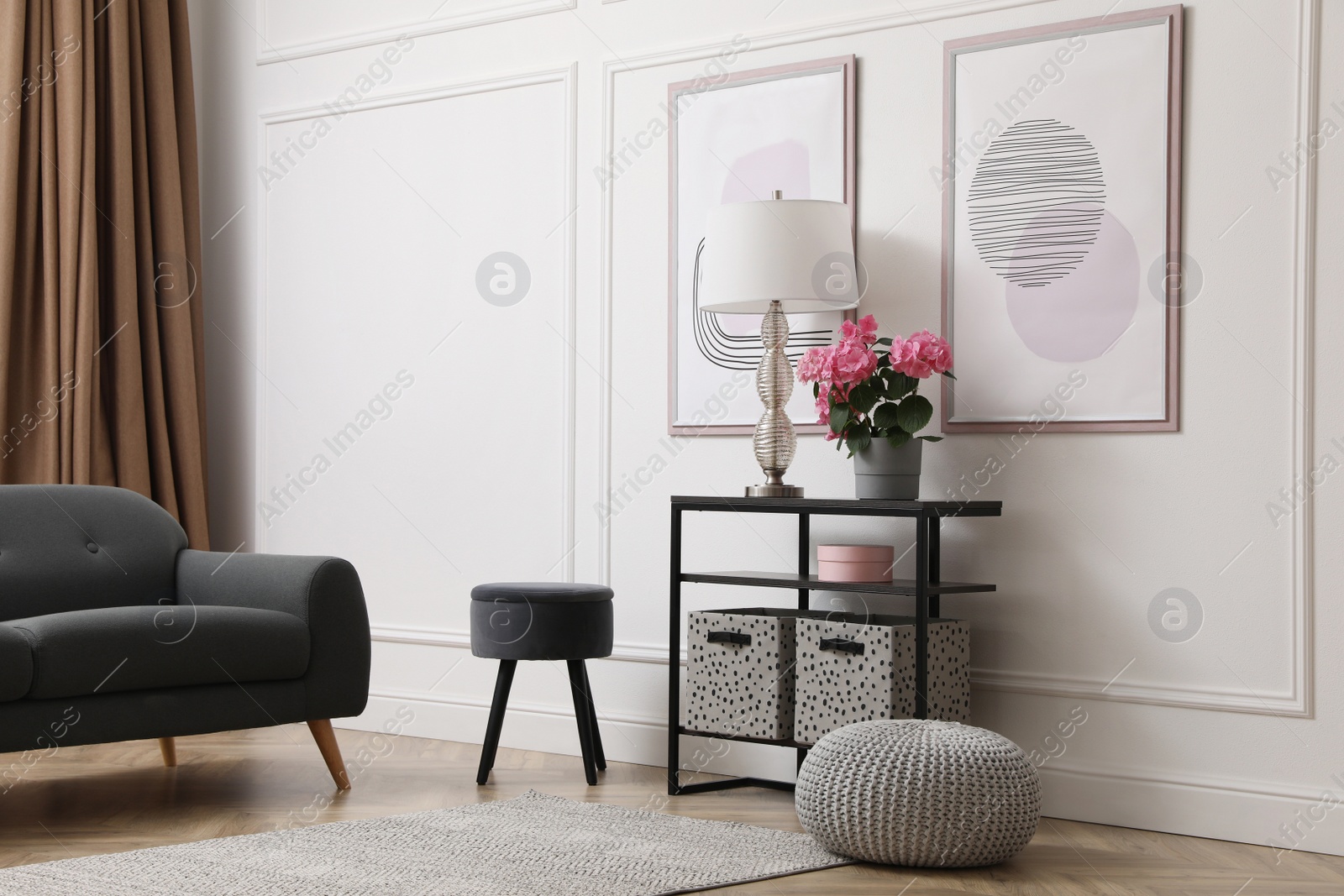 Photo of Console table with beautiful hydrangea flower and lamp near white wall in room. Interior design