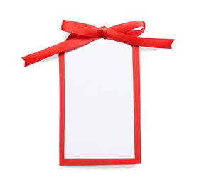 Photo of Blank gift tag with red satin ribbon on white background, top view