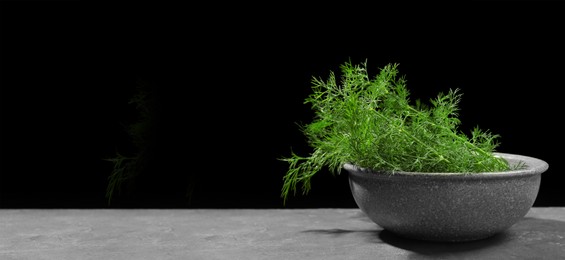 Image of Fresh dill in bowl on grey table against black background. Banner design with space for text