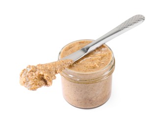 Photo of Delicious nut butter in jar and knife isolated on white