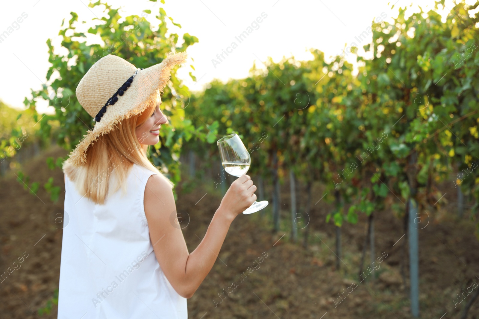 Photo of Young beautiful woman enjoying wine at vineyard. Space for text