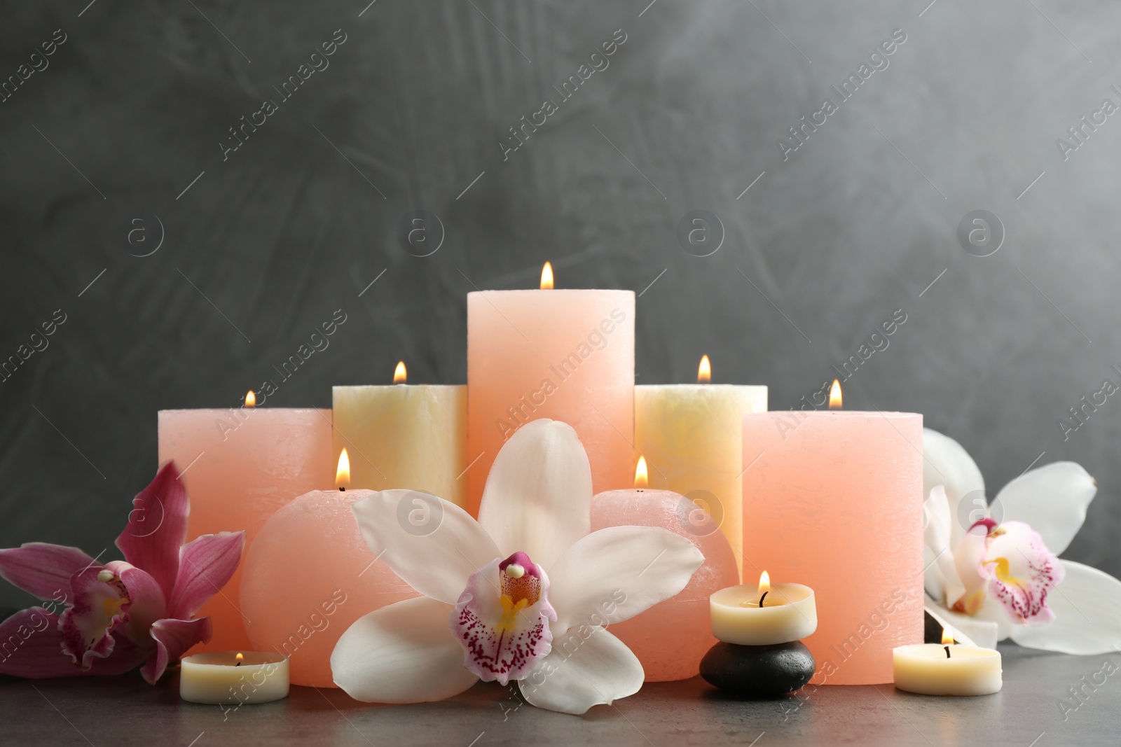 Photo of Beautiful composition with lit candles and flowers on table