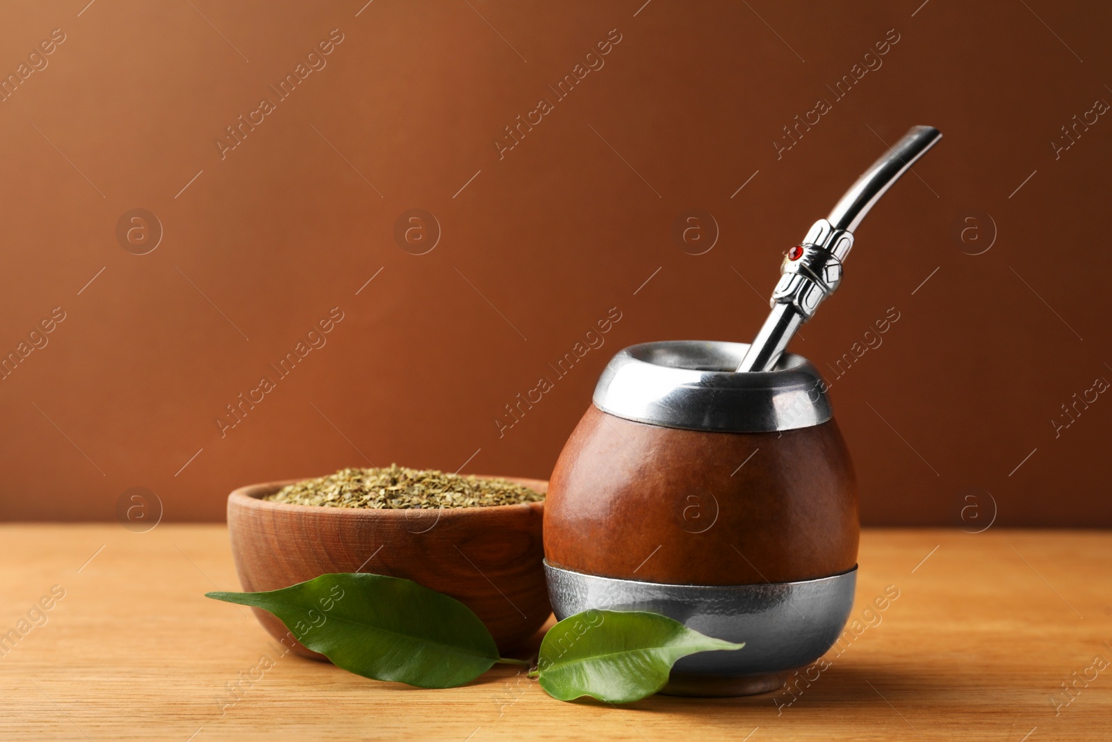 Photo of Calabash with mate tea and bombilla on wooden table